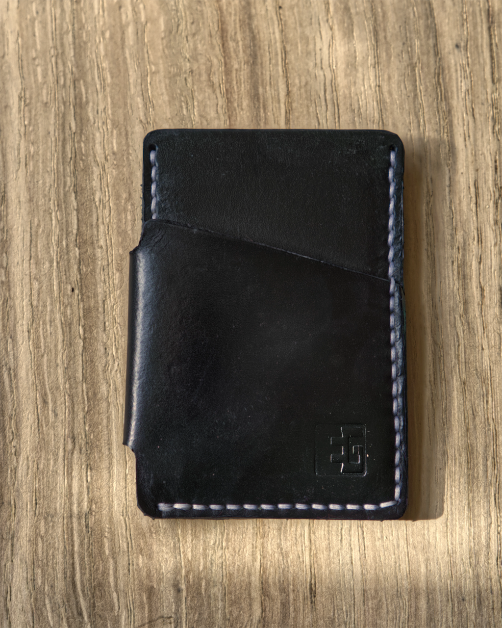 Black leather wallet on a wooden surface