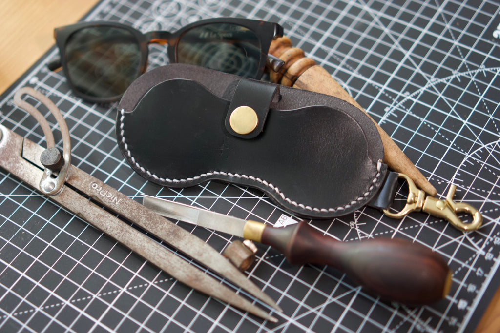 Leather eyewear case with sunglasses on a grid surface