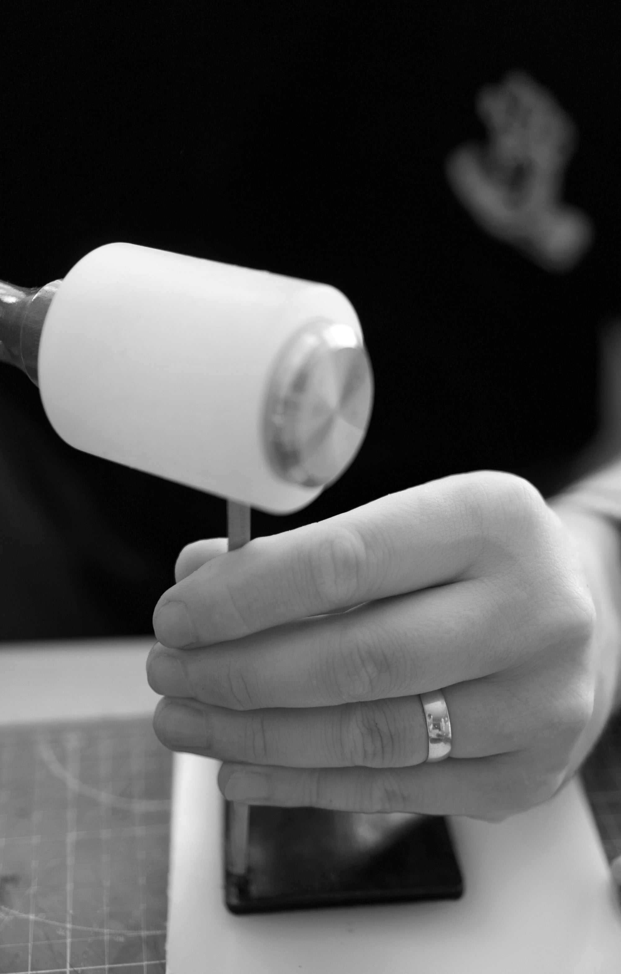 Hand holding a mallet with a blurred background